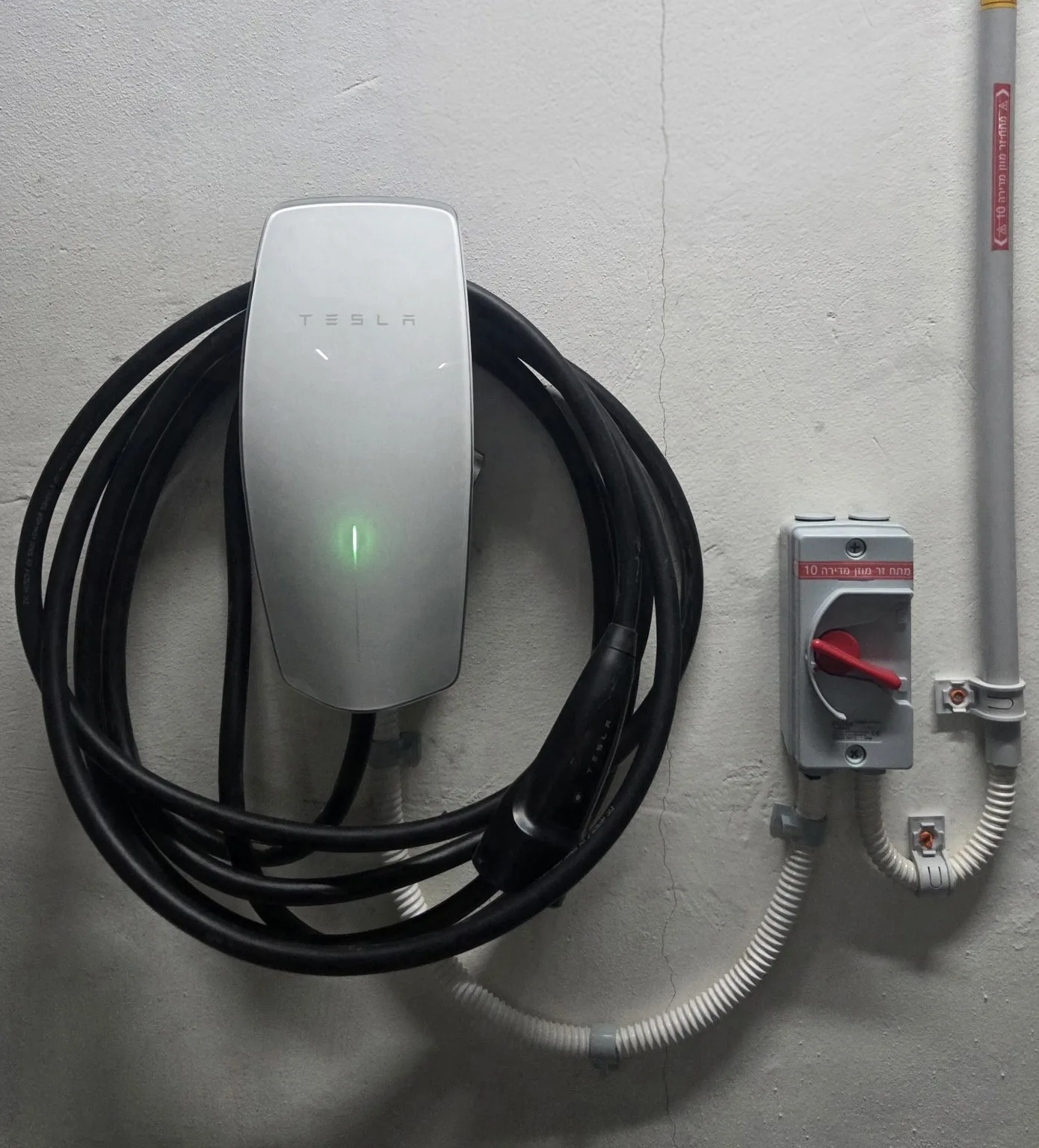 Tesla EV charger installed on a parking wall